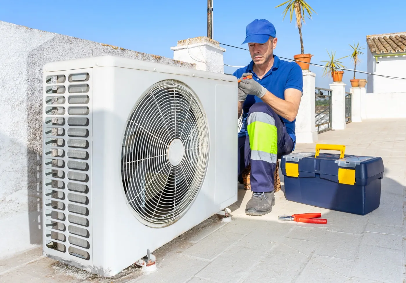 Family Heating & Cooling technician servicing an outdoor air conditioning unit